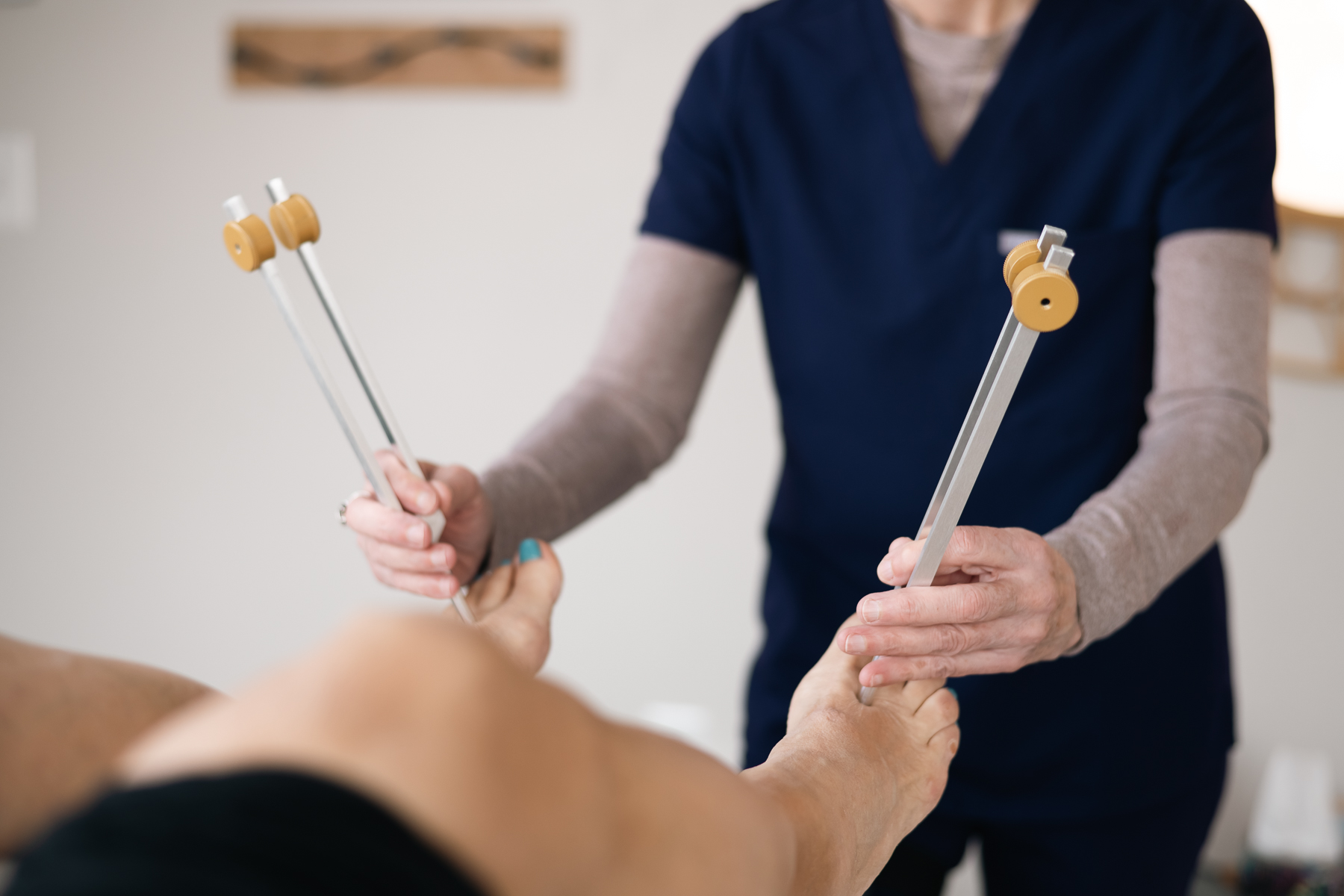 Tuning forks on a patient's feet during a sound therapy session
